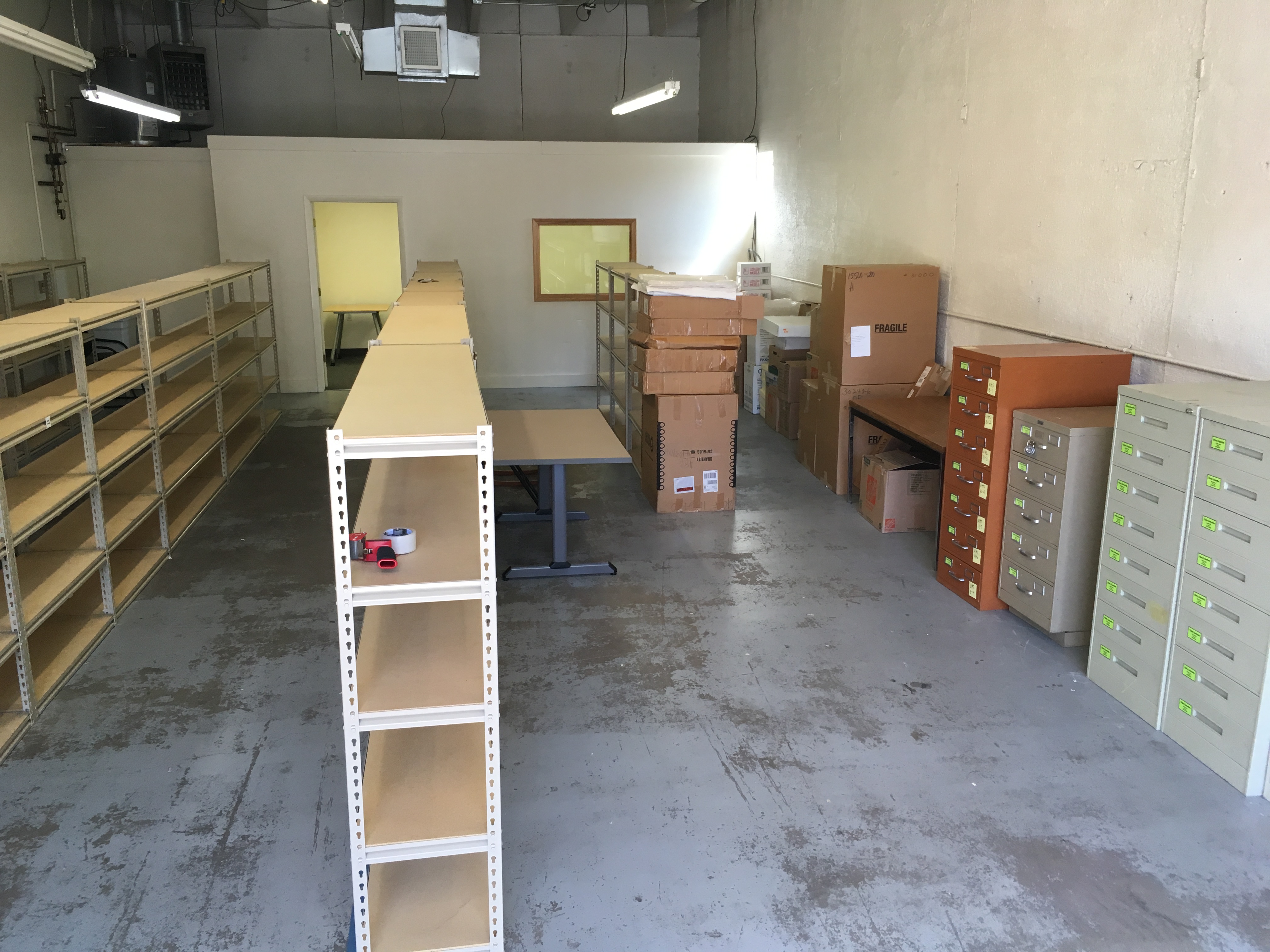 Empty shelves, tables, and metal cabinets surrounding a storage space.
