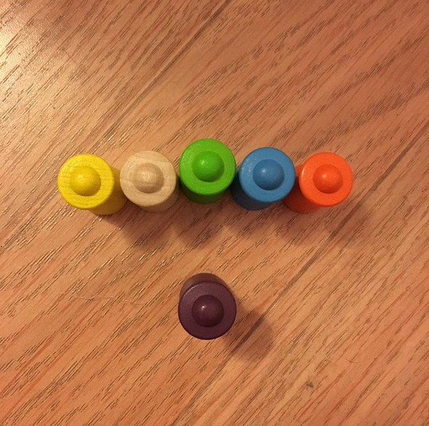 image of six markers from a board game arranged so that one faces a row of five