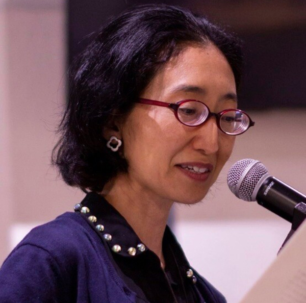 Photo of Sawako Nakayasu reading at a microphone.