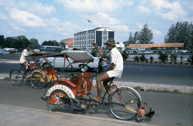A becak in Jakarta, 1968. Image courtesy of Tropenmuseum, part of the National Museum of World Cultures, via <a href=https://commons.wikimedia.org/wiki/File:COLLECTIE_TROPENMUSEUM_Becaks_bij_de_Britse_ambassade_TMnr_20018038.jpg>Wikimedia Commons</a>.
