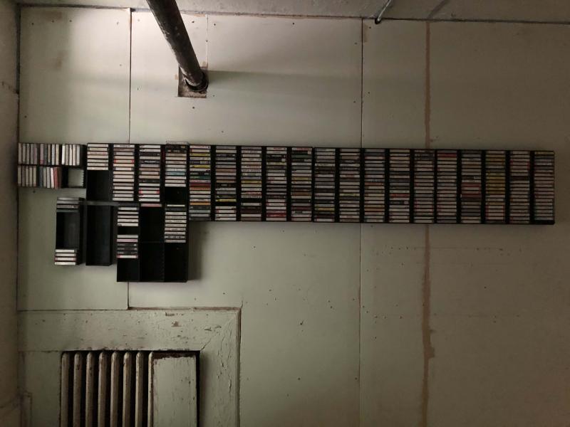 stacks of cassette tapes on a wall shelf