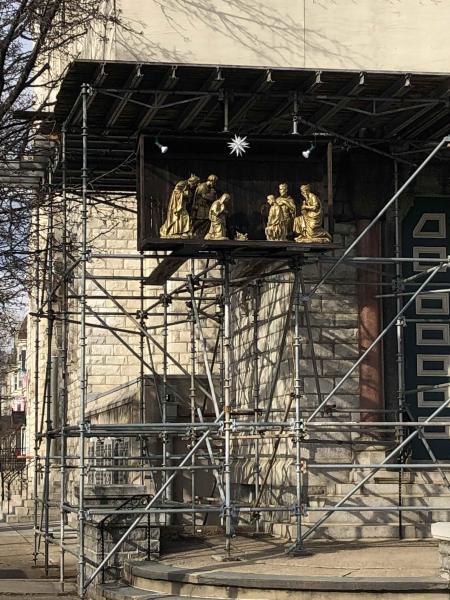 scaffolding on a building with a lofted nativity scene among it