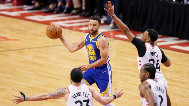 Steph Curry playing basketball, facing three defenders
