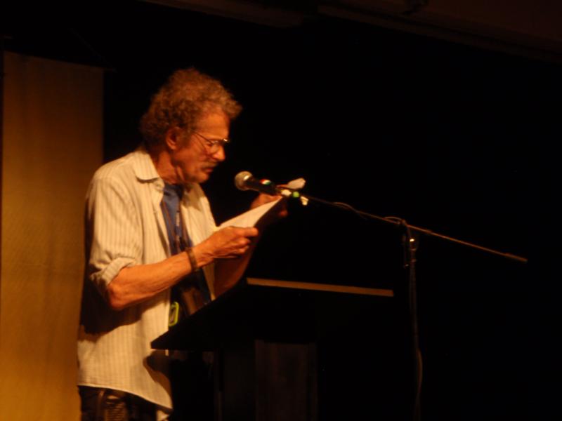 a photograph of the poet Jack Collom reading at Naropa University in June of 2011
