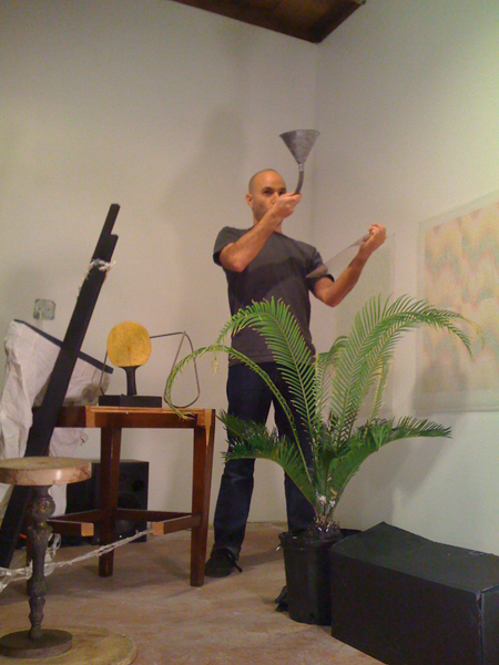 Marcus Civin performing in front of a drawing by Peter Wilson in the studio in the backyard