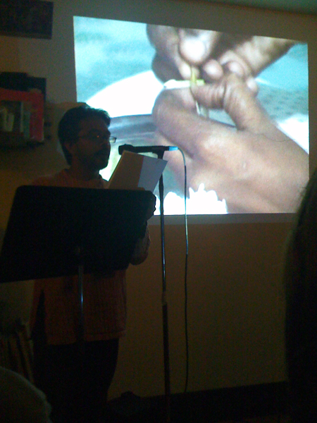 Amar Ravva performing excerpts from his forthcoming book American Canyon alongside projections, in the front room.